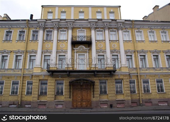Facade of old yellow building in St-Petersburg, Russia