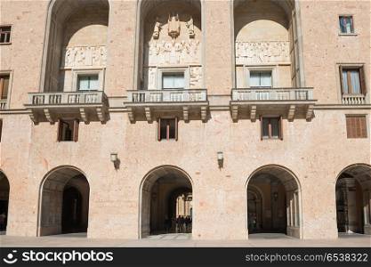 Facade with archs windows and balcony in Monastery Santa Maria de Montserrat Benedictine abbey located near Barcelona, Catalonia, Spain. Monastery, Santa Maria de Montserrat