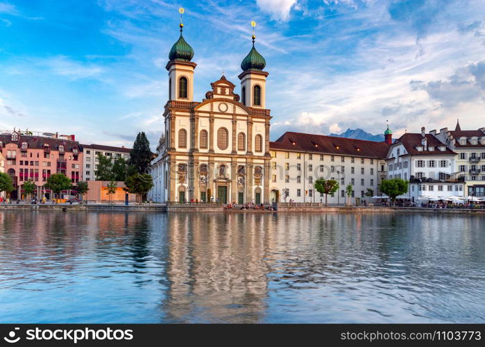 Facades of old medieval houses on the city embankment at sunrise. Lucerne. Switzerland.. Lucerne. Old city embankment and medieval houses at dawn.