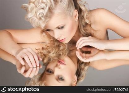 face and hands of beautiful woman with mirror