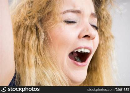 Face close up of funny woman yawing with wide open mouth. Sleeping problem, morning tiredness.. Funny woman yawning