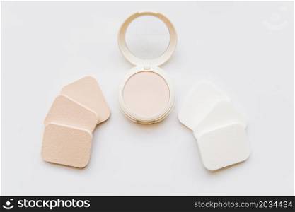 face cosmetic compact makeup powder with sponges white background