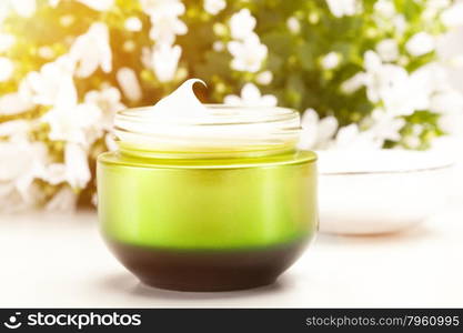 Face cream over flower background