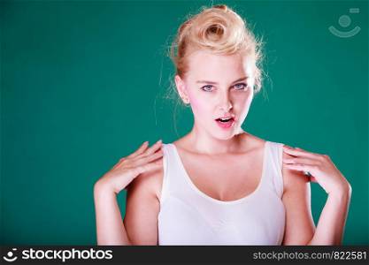 Face expression, emotions concept. Young woman with pin up hair being angry, shocked and disgust. Studio shot on green background. Angry young woman with pin up hair