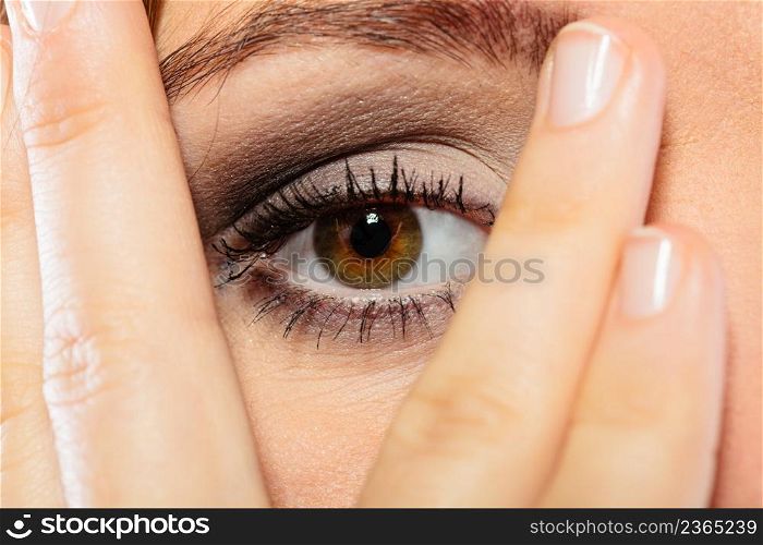 Face expressions emotion and distress. Female wear makeup cover her face with hand look through fingers.. Woman cover face look through fingers.