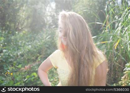 Face half hide by hair. Pretty blonde outdoors. Colorized image