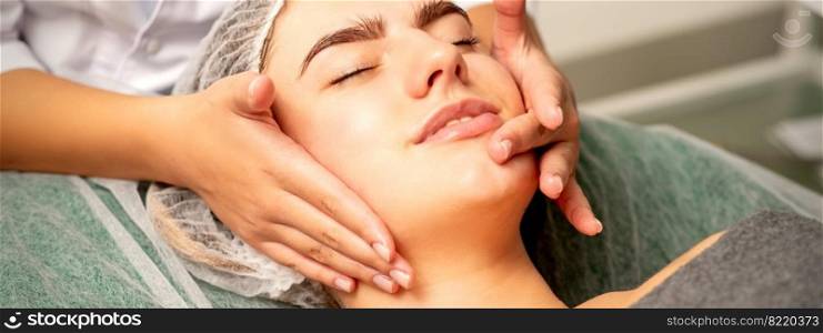 Face massage. Beautiful caucasian young white woman having a facial massage with closed eyes in a spa salon. Face massage. Beautiful caucasian young white woman having a facial massage with closed eyes in a spa salon.