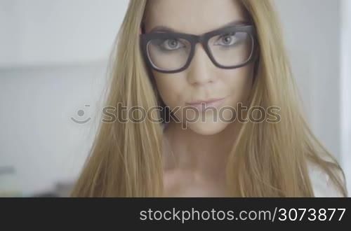 face of a pretty brunette woman wearing glasses.