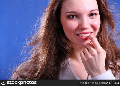 Face of a Pretty young woman touch to lips - on blue background