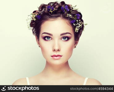 Face of beautiful woman decorated with flowers. Perfect makeup. Beauty fashion. Eyelashes. Cosmetic Eyeshadow