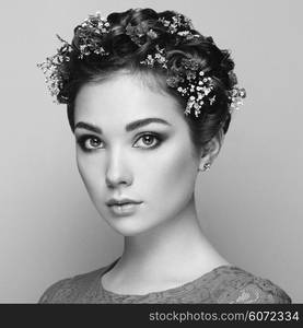 Face of beautiful woman decorated with flowers. Perfect makeup. Beauty fashion. Eyelashes. Cosmetic Eyeshadow. Black and white