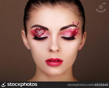 Face of beautiful woman with holiday makeup heart. Beauty fashion. Lips in red lipstick. Eyelashes. Cosmetic Eyeshadow. Makeup detail