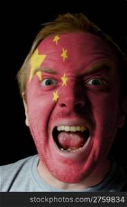 Face of crazy angry man painted in colors of China flag