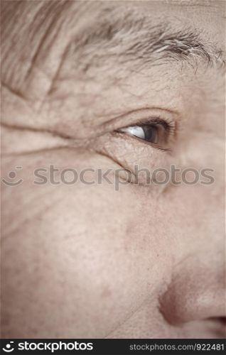 Face of elderly man looking away. Vertical photo