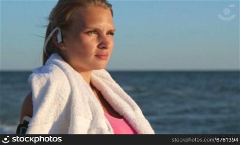 Face of fitness girl relax listening to music after workout on the beach