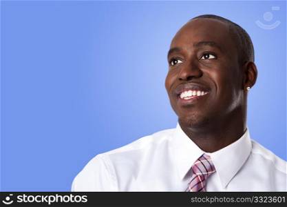 Face of handsome happy African American corporate business man smiling, wearing white shirt and pink with stripes necktie on a blue sky-like background.