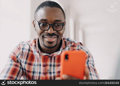 Face of happy african american man. Freelancer has video call on phone. Working remotely from home on quarantine. Consulting or corporate discussion. Distance briefing. Workplace while the pandemic.. Face of happy african american man. Freelancer is working remotely from home on quarantine.