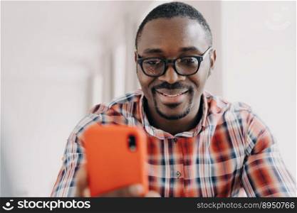 Face of happy african american man. Freelancer has video call on phone. Working remotely from home on quarantine. Consulting or corporate discussion. Distance briefing. Workplace while the pandemic.. Face of happy african american man. Freelancer is working remotely from home on quarantine.
