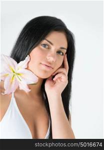 Face of pensive young woman with flower. Beauty treatment concept