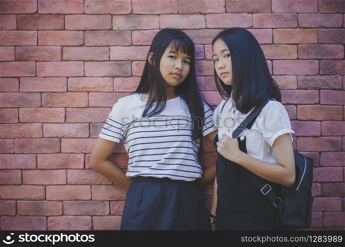 face of two asian teenager standing and looking to camera with eye contact