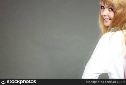 Face of young blonde woman with bangs gray background copy space text area
