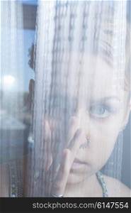 Face of young woman behind transparent cloth closeup