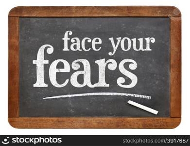 Face your fears advice on a vintage slate blackboard isolated on white