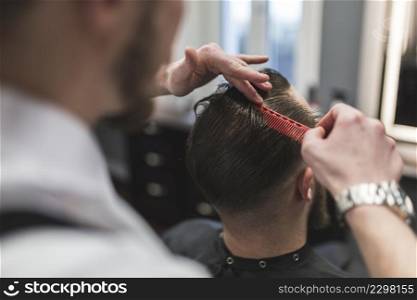 faceless barber combing hair man before cutting