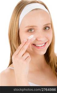 Facial care teenager woman apply cream on white