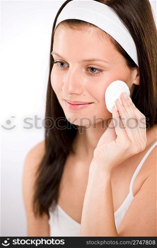 Facial care - woman removing make-up with cotton pad