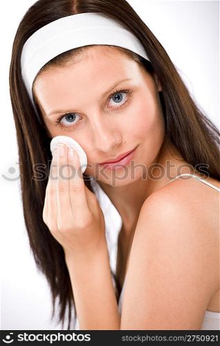 Facial care - woman removing make-up with cotton pad