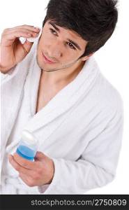 Facial care - Young man cleaning face with lotion on white background