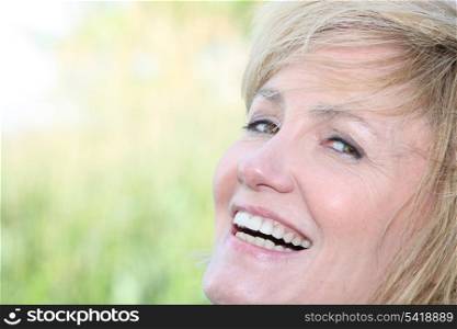 Facial closeup of a smiling woman with a wide grin