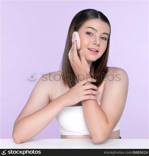 Facial cosmetic makeup concept. Portrait of young charming girl applying dry powder foundation. Beautiful girl smiling with perfect skin putting cosmetic makeup on her face.. Portrait of young charming girl applying dry powder foundation on her face.