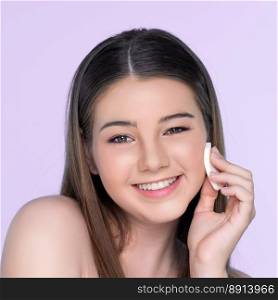Facial cosmetic makeup concept. Portrait of young charming girl applying dry powder foundation. Beautiful  girl smiling with perfect skin putting cosmetic makeup on her face.. Portrait of young charming girl applying dry powder foundation on her face.