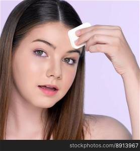 Facial cosmetic makeup concept. Portrait of young charming girl applying dry powder foundation. Beautiful  girl smiling with perfect skin putting cosmetic makeup on her face.. Portrait of young charming girl applying dry powder foundation on her face.