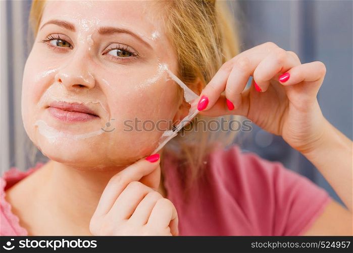 Facial dry skin and body care, complexion treatment at home concept. Woman removing gel peel off mask from face. Woman peeling off gel mask from face