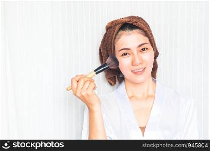 Facial Makeup. Beautiful Asian Female Model Putting Blush With Cosmetic Brush. Portrait Of Attractive Healthy 30+ Year Old Woman With Pure Clean Skin And Natural Make-Up. Beauty Concept.