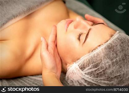 Facial massage. Hands of a masseur massaging neck of a young caucasian woman in a spa salon, the concept of health massage. Facial massage. Hands of a masseur massaging neck of a young caucasian woman in a spa salon, the concept of health massage.