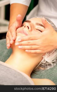 Facial treatment massage. Beautiful young caucasian woman with perfect skin receiving face and neck massage at a beauty spa. Facial treatment massage. Beautiful young caucasian woman with perfect skin receiving face and neck massage at a beauty spa.