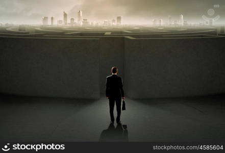 Facing challenge. Successful businessman standing near the entrance of labyrinth