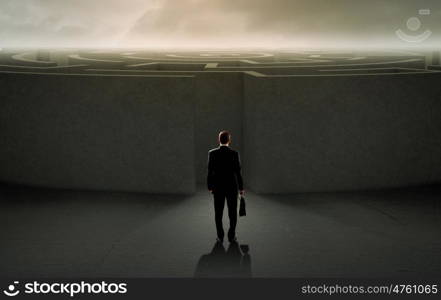 Facing challenge. Successful businessman standing near the entrance of labyrinth