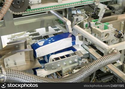 factory and equipment for the production of female sanitary napkins. packing equipment for women&rsquo;s sanitary napkins on a conveyor belt closeup. production of women&rsquo;s sanitary napkins