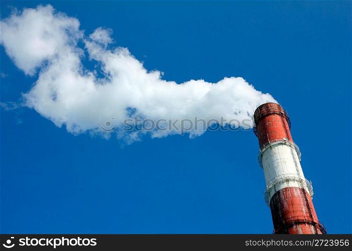 factory chimney with smoke under blue sky