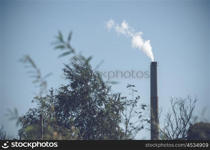 Factory chimney with white smoke in the nature
