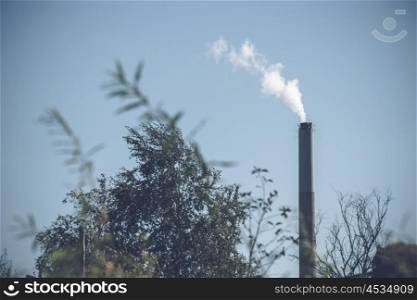 Factory chimney with white smoke in the nature