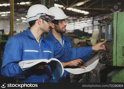 Factory Engineer or mechanical worker with white safety helmet checking on production in a factory. Industrial,Warehouse Heavy Mechanic, Engineering Concept.