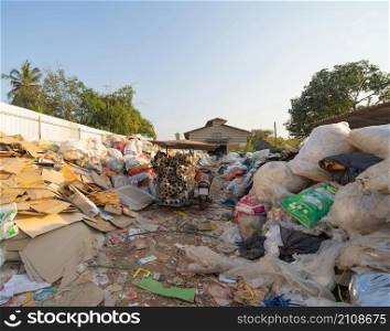 Factory industry with stack of different types of large garbage dump, plastic bags, bottles and trash bins in urban area in Environmental pollution concept.