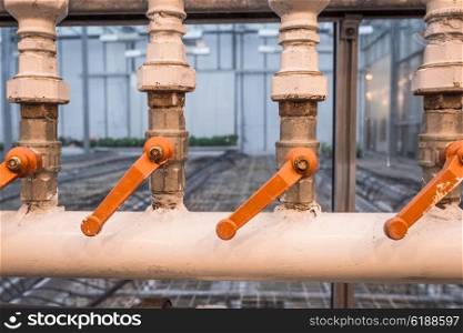 Factory pipes with orange handles for regulation of water