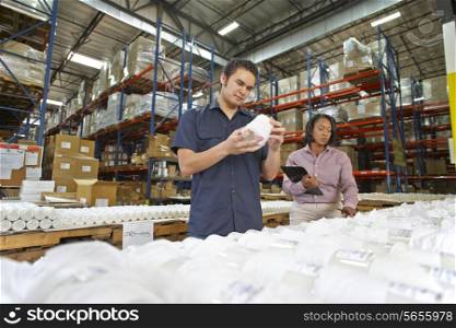 Factory Worker And Manager Checking Goods On Production Line